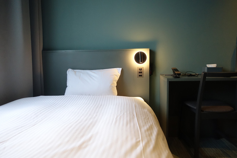 ジネスホテルのシンプルな客室とベッド