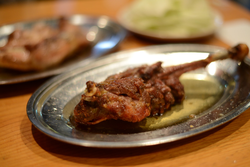 骨付鳥の親鳥（骨付き鶏もも肉1本）を鉄皿で焼いた様子。皮は香ばしく肉は引き締まっている